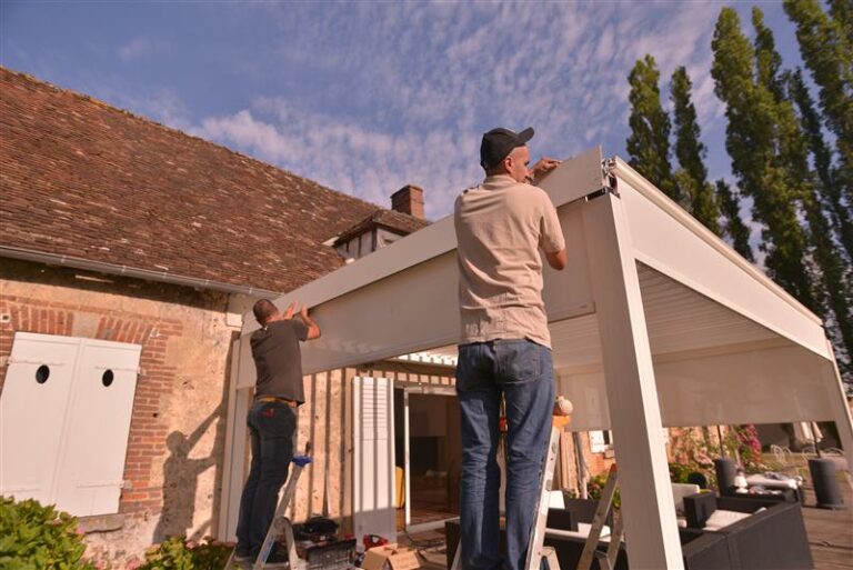 Installation de stores en aluminium de fabrication européenne sur une pergola adossée à une maison ancienne
