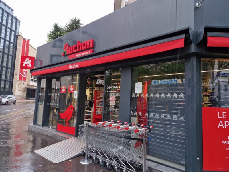 Devanture d'un magasin auchan avec store banne personnalisé avec logo